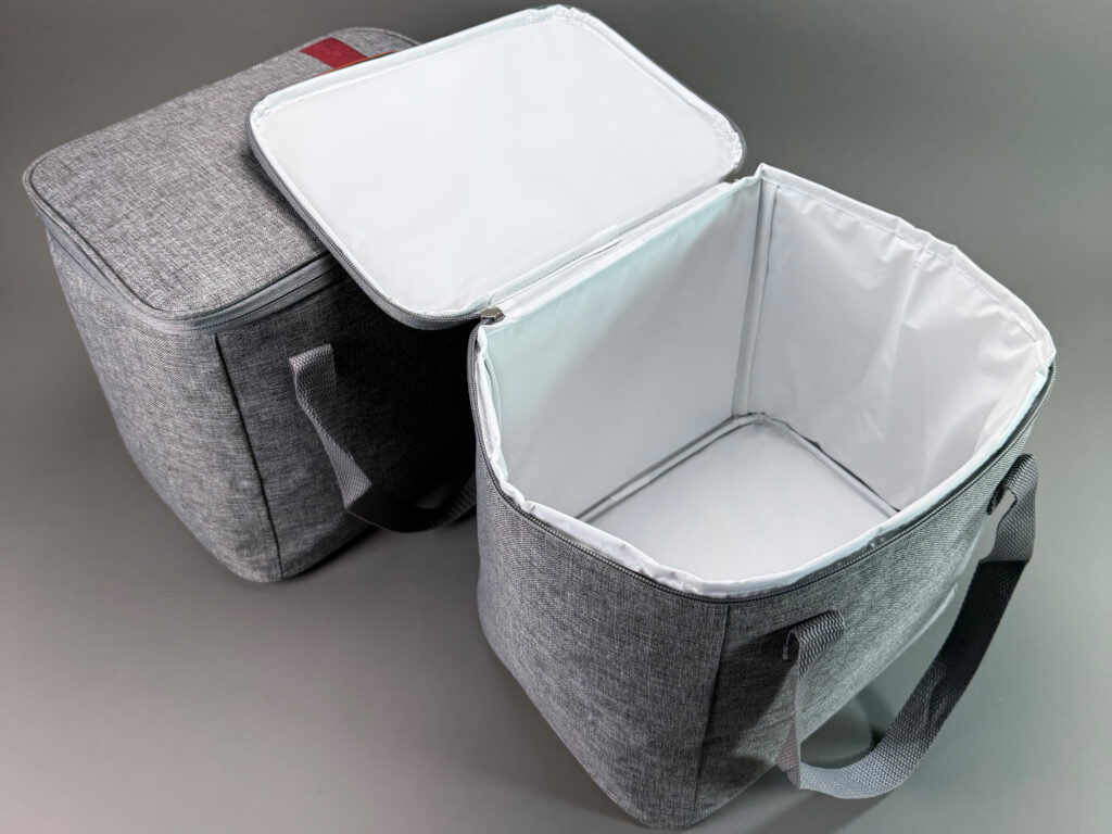 Geoeffnete Kuehltasche mit weisser Thermo-Innenausstattung und umlaufendem Reissverschluss