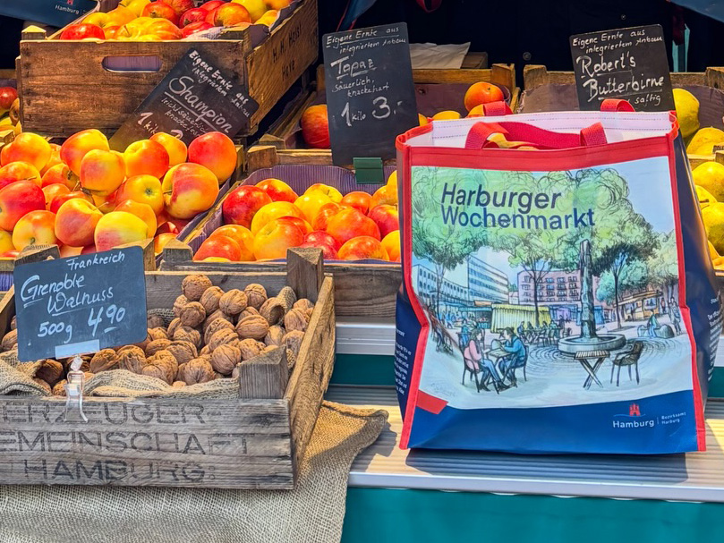 Markttasche auf dem Marktstand zwischen Aepfeln und Walnuessen