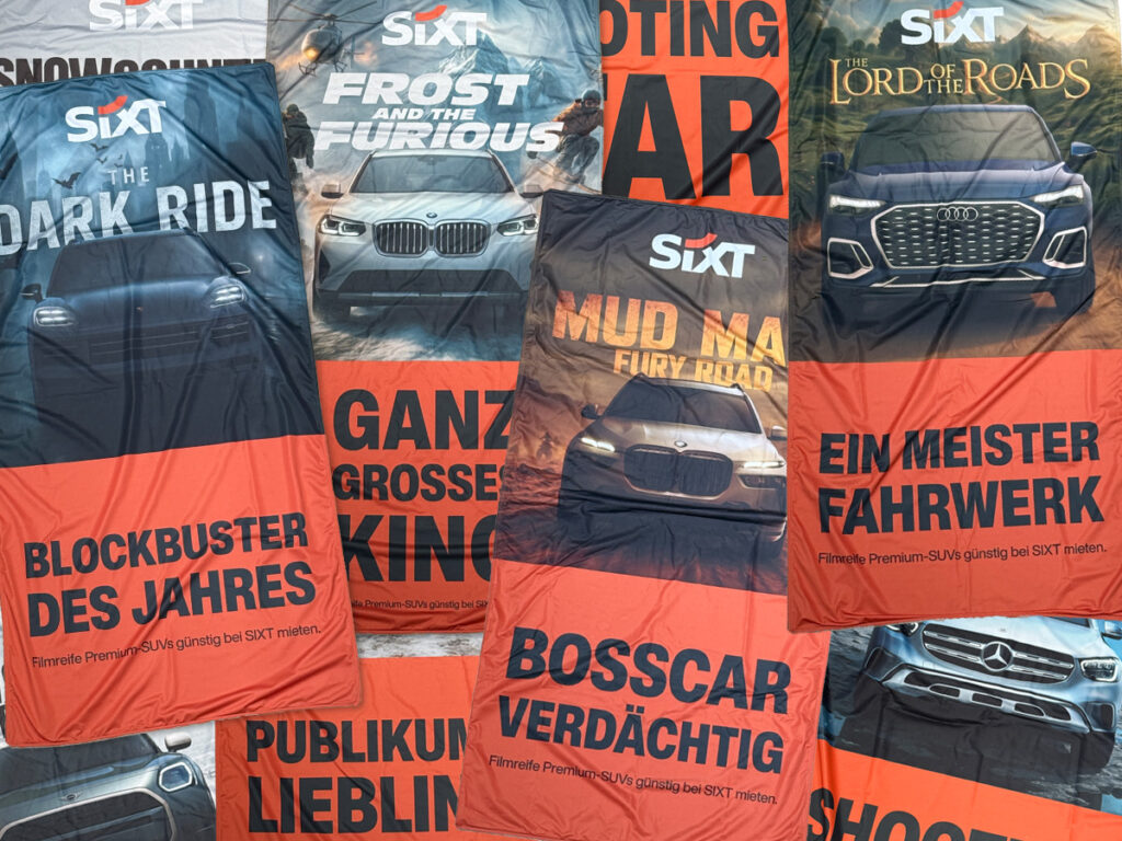 Das erste Leben: Sixt-Kampagnenbanner mit den typischen Wortspielen, von Blockbuster des Jahres bis Ein Meister Fahrwerk