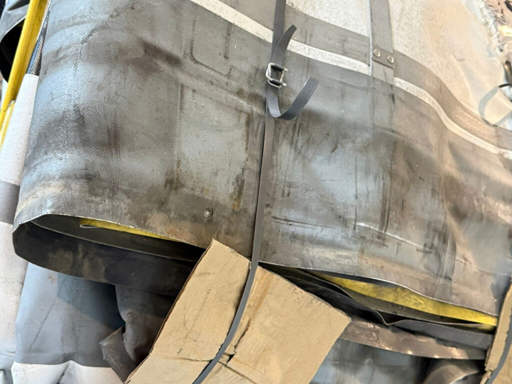 Detail des Ausgangsmaterials mit Spanngurten und Gebrauchsspuren