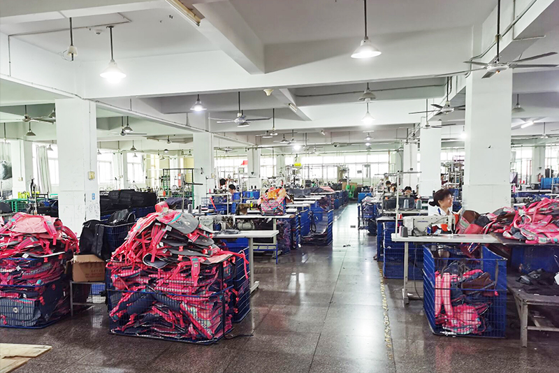 Große Näherei in unserem Partnerwerk in Xiamen, im Vordergrund Gitterboxen mit fertig genähten Rucksäcken
